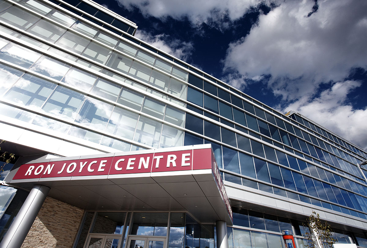 A view of the front door, sign and building that is the Ron Joyce Center